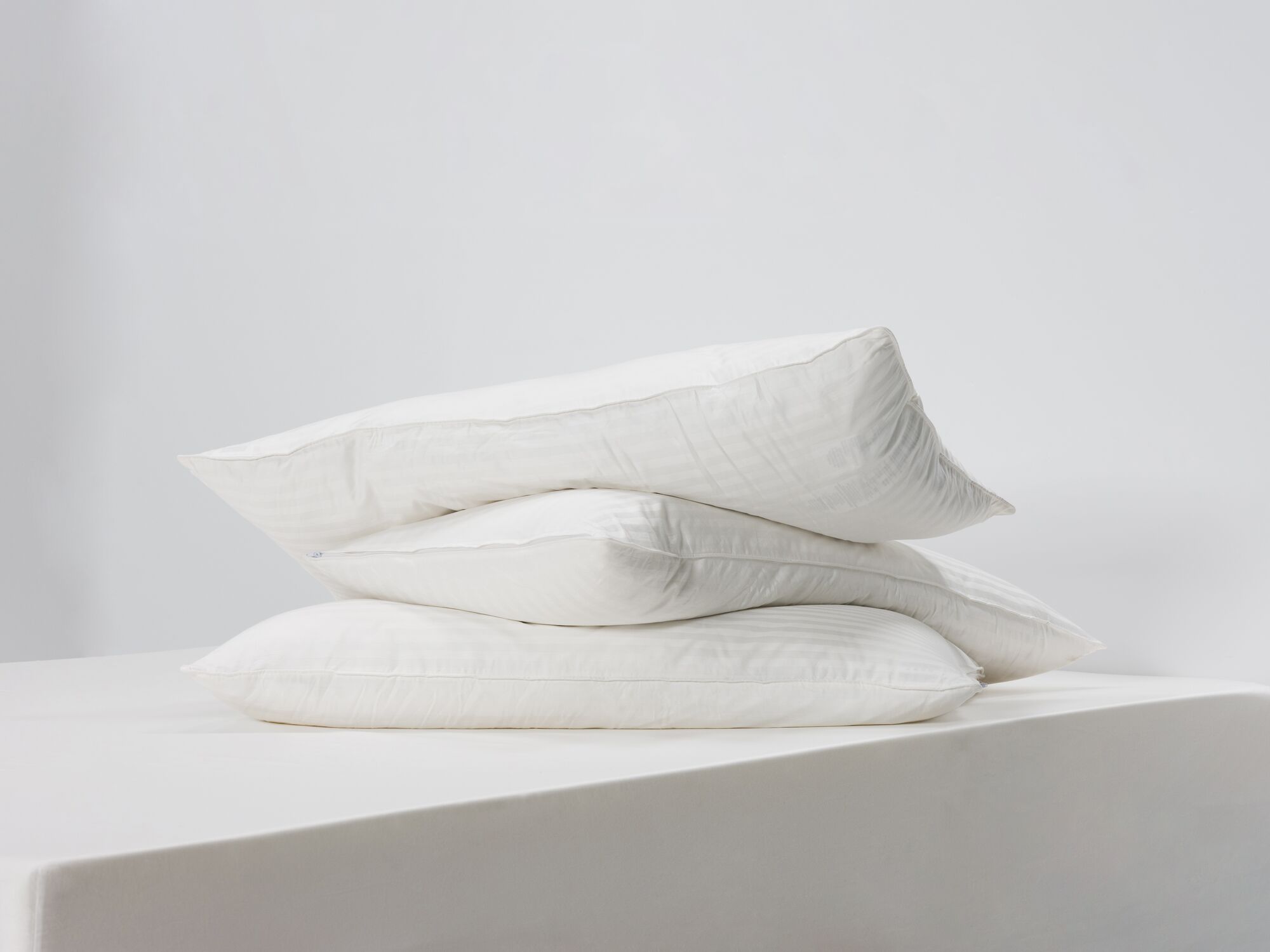Side angle view of three king down pillows